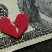 Broken Heart on top of a dollar bill